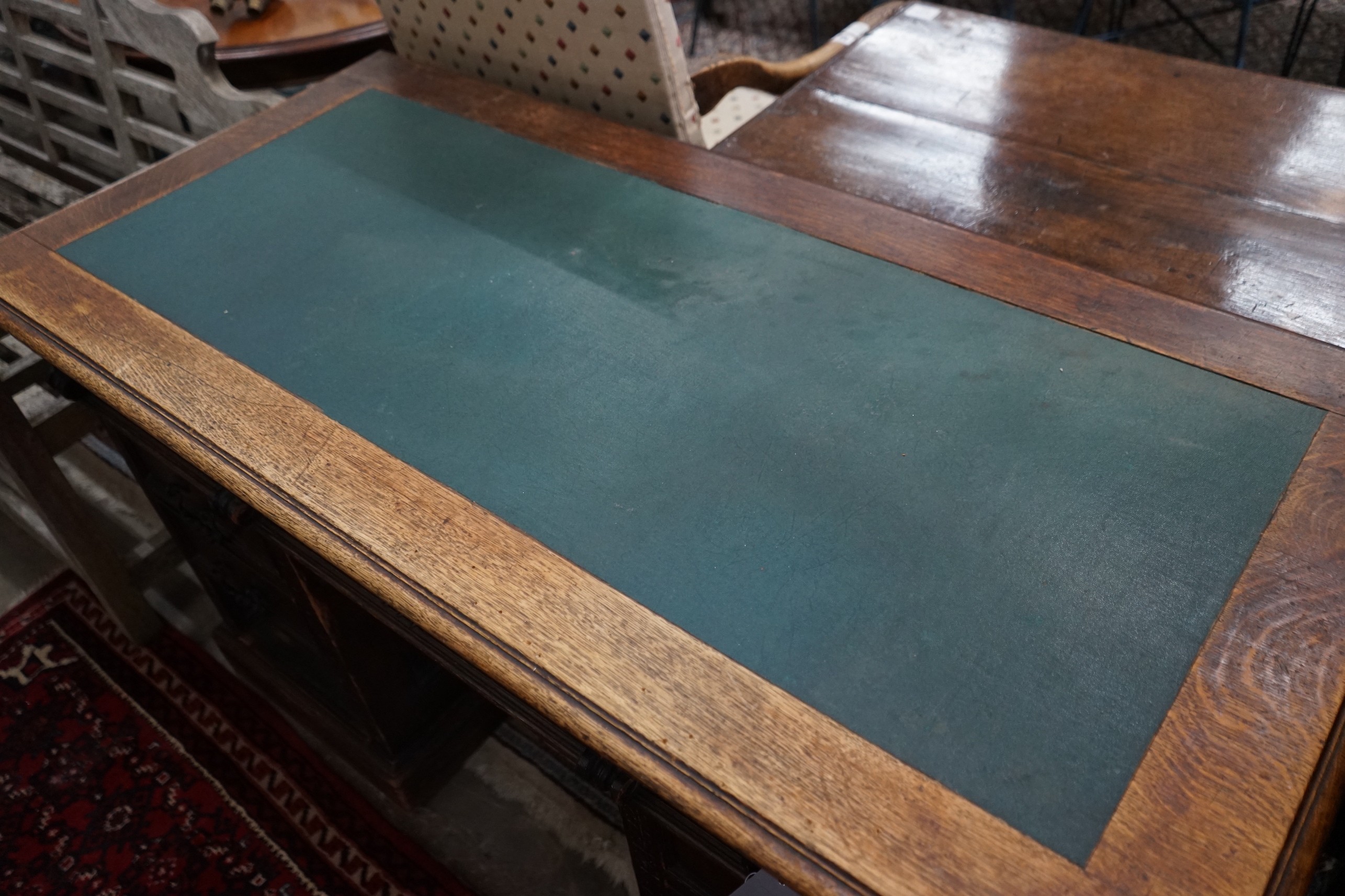 A late Victorian carved oak pedestal desk, length 137cm, depth 65cm, height 77cm